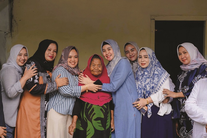BAHAGIA: Ketua TP PKK Sampang Selviana Slamet Junaidi (empat dari kanan) merangkul duafa usai menyerahkan bantuan sembako di Kelurahan Banyuanyar, Rabu (22/10). (PROTOKOL PEMKAB SAMPANG UNTUK JPRM)