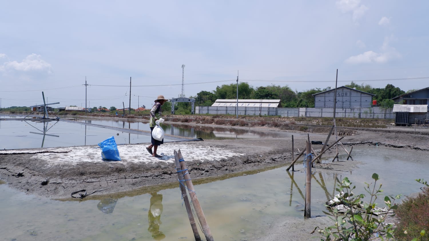 PEREKONOMIAN: Seorang pria sedang memasukkan garam ke dalam karung di Desa Gili Barat, Kecamatan Kamal, Bangkalan, Kamis (23/10).