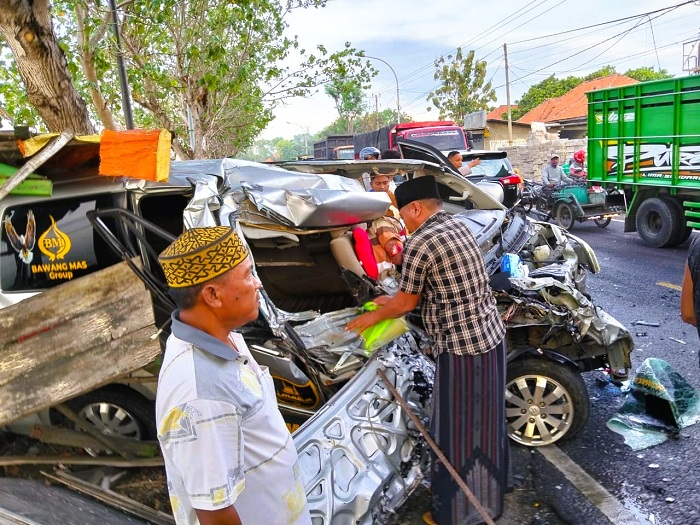 RINGSEK: Warga berupaya mengevakuasi jenazah korban laka di jalan raya Desa Sejati, Kecamatan Camplong, Sampang, Selasa (28/10). (ANIS BILLAH/JPRM)