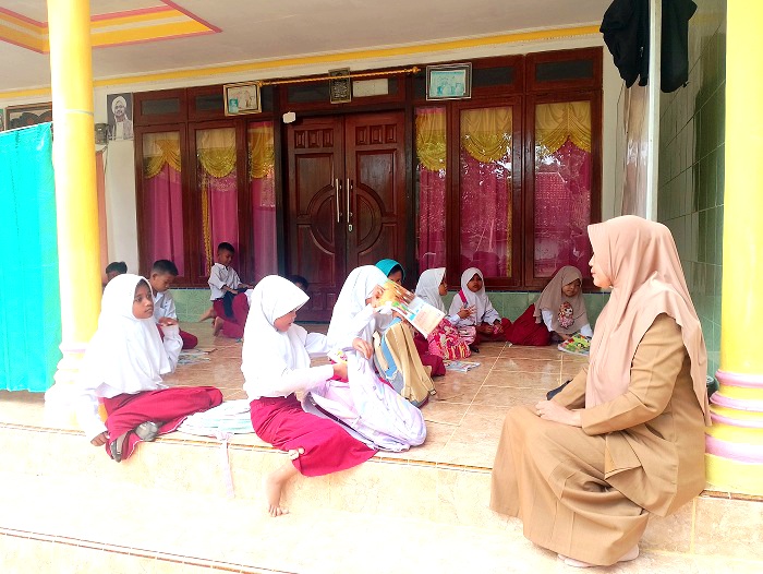 TAK REPRESENTATIF: Siswa kelas III SDN Madulang 2 Sampang mengikuti KBM di teras rumah warga Senin (27/10). (UBAIDILLAHIR RAIE/JPRM)