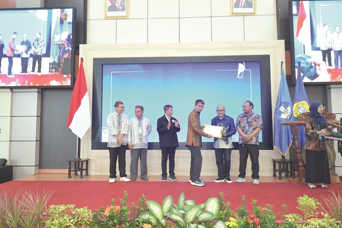 KENANG-KENANGAN: Warek Bidang Akademik UTM Prof Achmad Amzeri&nbsp; menyerahkan piagam penghargaan kepada Medhy Aginta Hidayat (batik biru) Rabu (29/10).
