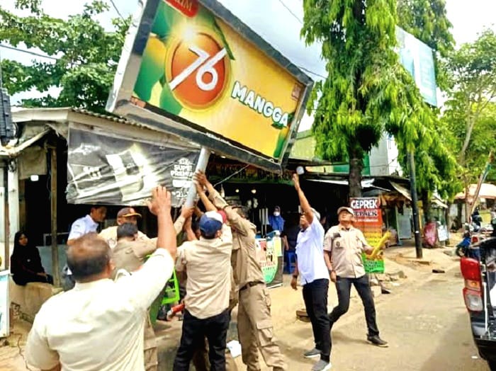 DITERTIBKAN: Tim Pemkab Sumenep saat melakukan penertiban reklame tidak berizin di Jalan Trunojoyo, Sumenep, Rabu (29/10). (SATPOL PP UNTUK JPRM)