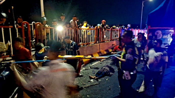 TERLIBAT LAKA: Petugas dan warga mengevakuasi korban kecelakaan lalu lintas di Jembatan Suramadu, Kamis (30/10) dini hari. (SATLANTAS POLRES BANGKALAN UNTUK JPRM)