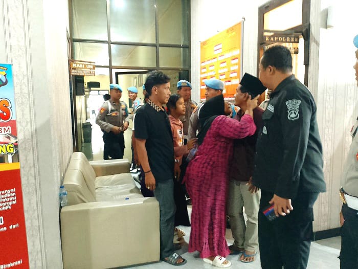 DIKAWAL KELUARGA: Seorang perempuan hendak mencium Mad Jari setelah keluar dari ruang Kapolres Sampang, Rabu (29/10). (UBAIDILLAHIR RAIE/JPRM)