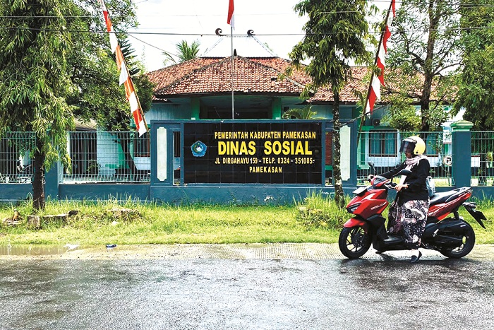 BASAH: Pengemudi kendaraan bermotor melintas di depan kantor Dinsos Pamekasan Selasa (4/11). (FAHMI JALIL/JPRM)