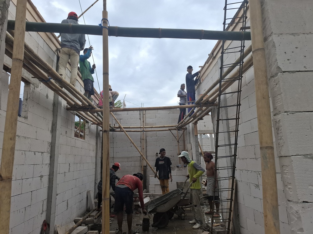 PROGRES: Para buruh sedang mengerjakan proyek pembangunan gedung pelayanan Satlantas Polres Sumenep, Kamis (30/10).