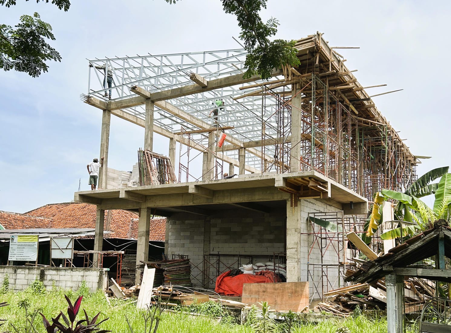 LAMBAT: Tukang melaksanakan pengerjaan atap dalam pembangunan proyek Puskesmas Burneh.