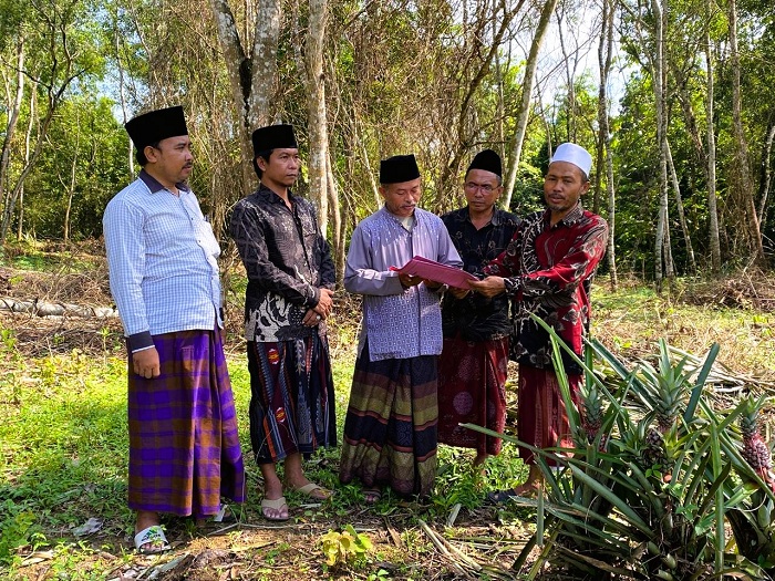 DIPASRAHKAN: Perwakilan keluarga Hasan Basri (batik merah) menyerahkan wakaf kepada panitia pengelola TPU disaksikan Kades Tlagah Syaifuddin (kiri), Kades Lerpak Baikuni (dua dari kiri), dan tomas.
