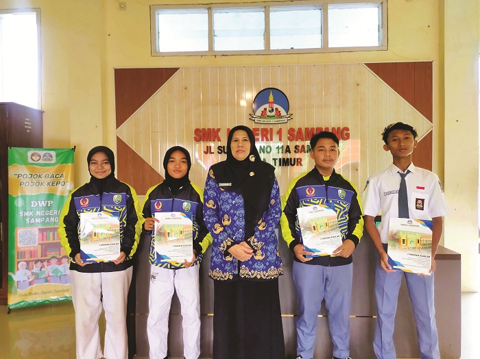 BERPRESTASI: Kepala SMKN 1 Sampang Rahmawati berfoto bersama dengan siswa berprestasi pada momen Hari Pahlawan di sekolahnya Senin (10/11). (SMKN 1 SAMPANG UNTUK JPRM)