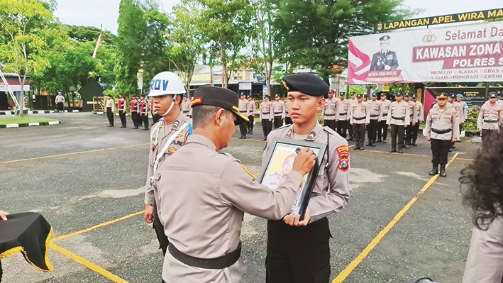 SIMBOLIS: Kapolres Sampang AKBP Hartono melakukan PTDH secara simbolis terhadap Sunarto di halaman Mapolres Sampang Rabu (12/11). (HUMAS POLRES UNTUK JPRM 0
