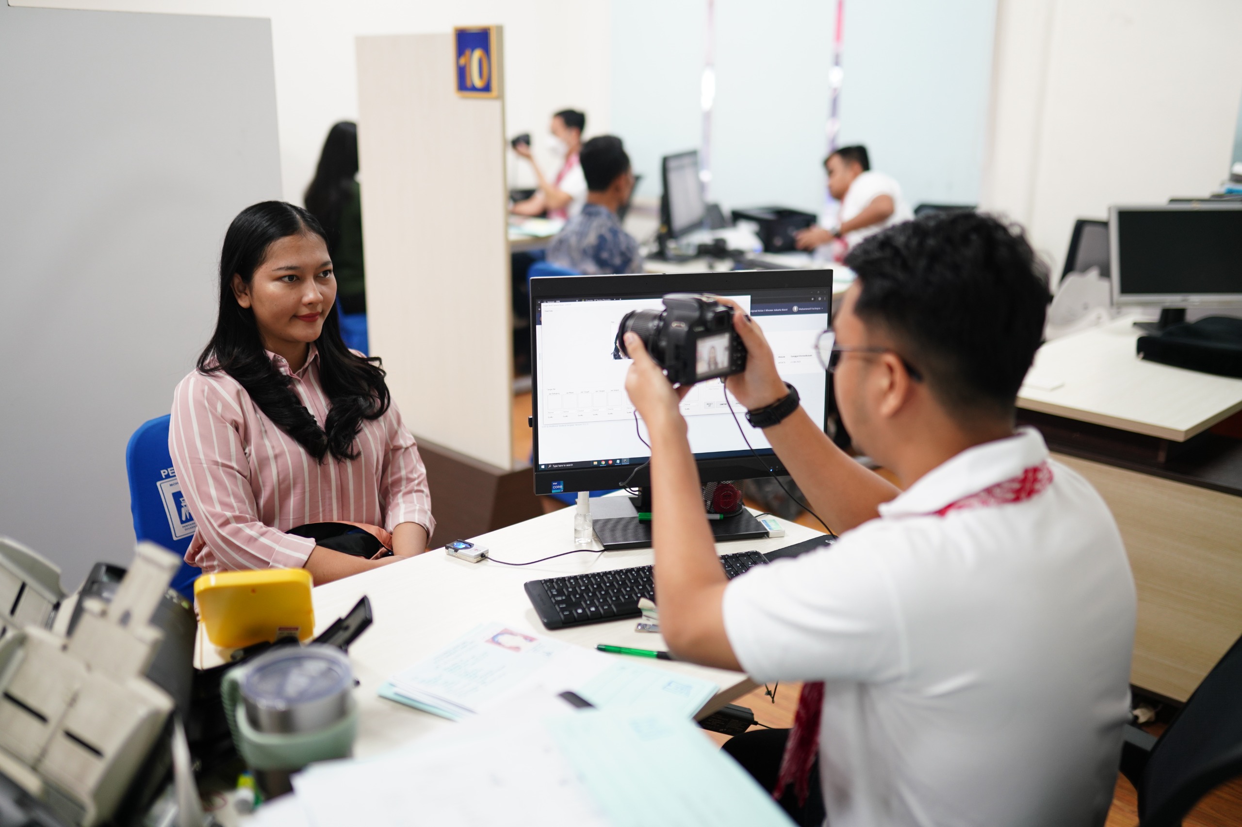 Petugas Imigrasi melakukan perekaman data masyarakat yang mengurus paspor.