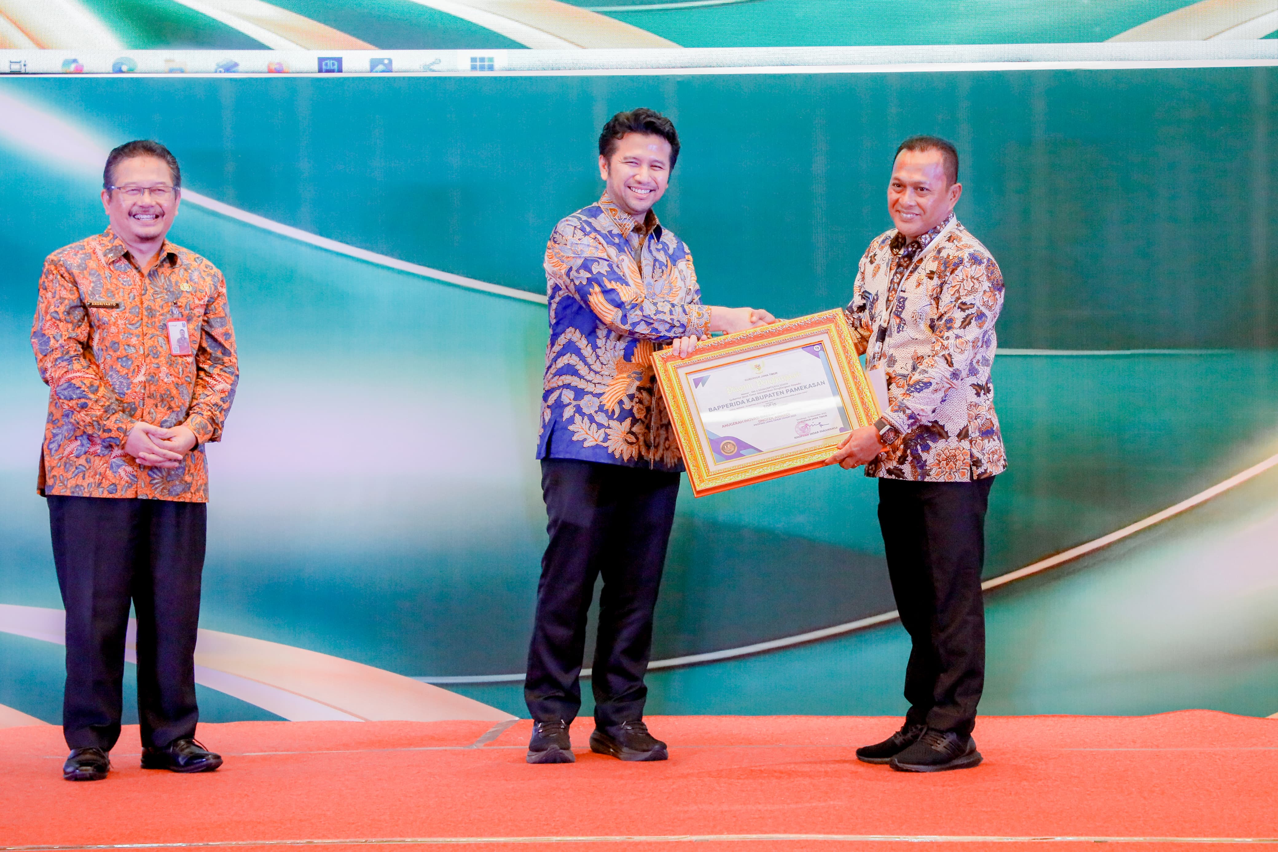 BAHAGIA: Wabup Pamekasan H Sukriyanto (kanan) menerima penghargaan dari Wagub Jatim Emil Elestianto Dardak didampingi Kepala Brida Andriyanto di Hotel Mercure Surabaya Grand Mirama, Kamis (13/11).