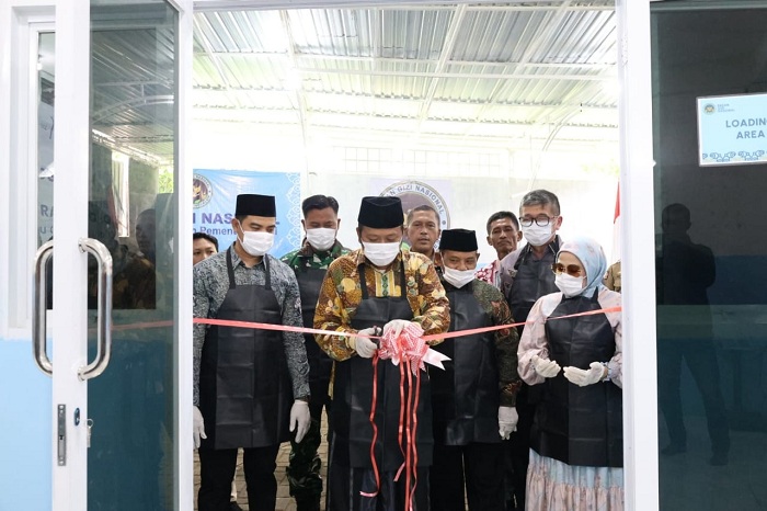 SIMBOLIS: Wabup Sampang Ahmad Mahfudz menggunting pita sebagai tanda peresmian SPPG Madulang, Omben, Sampang, Minggu (16/11). (PROTOKOL UNTUK JPRM)