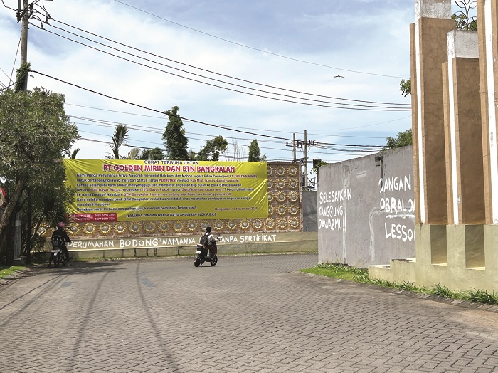 TANPA KEJELASAN: Warga melintas di pintu masuk Perumahan Griya Anugerah, Kelurahan Mlajah, Bangkalan, Selasa (18/11). (VIVIN AGUSTIN HARTONO/JPRM)