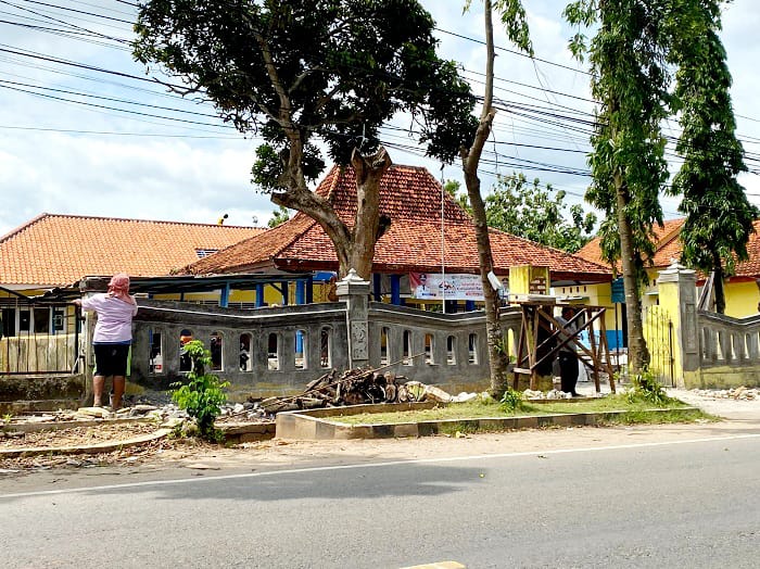 TAK TUNTAS: Tukang merehabilitasi pagar kantor Kecamatan Tanjungbumi, Sabtu (15/11). (JUPRI/JPRM)