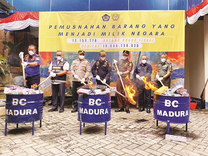 SIMBOLIS: Kepala KPPBC TMP C Madura Novian Dermawan (tengah) bersama forkopimda memusnahkan rokok di halaman kantor Rabu (19/11). (MOH. IQBAL AFGANI/JPRM)