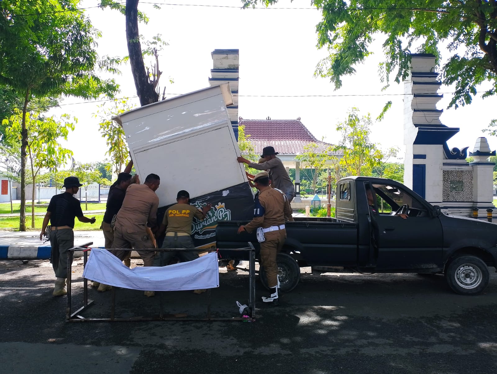 DITERTIBKAN: Petugas Satpol PP Sampang menertibkan gerobak PKL yang melanggar di Jalan Wijaya Kusuma, Sampang, Rabu (19/11).