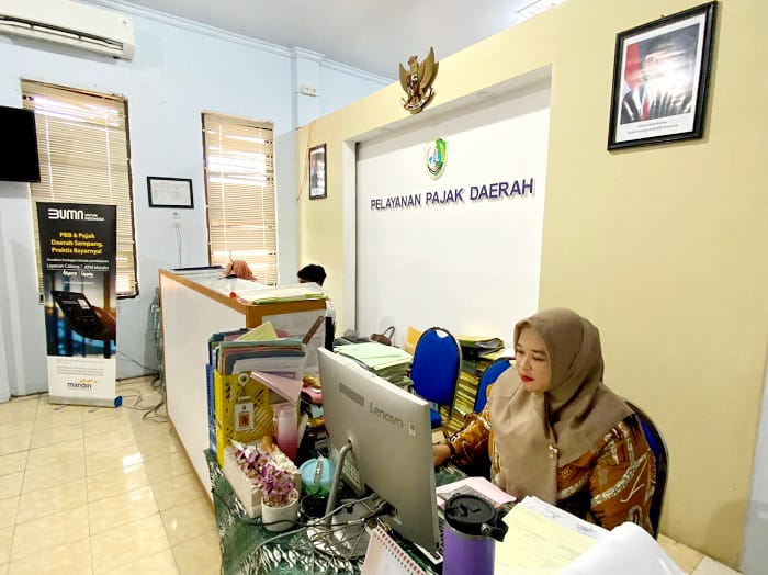 LENGANG: Petugas penerimaan pembayaran pajak BPPAKD Sampang berada di tempat kerjanya Kamis (20/11). (AYU LATIFAH/JPRM)