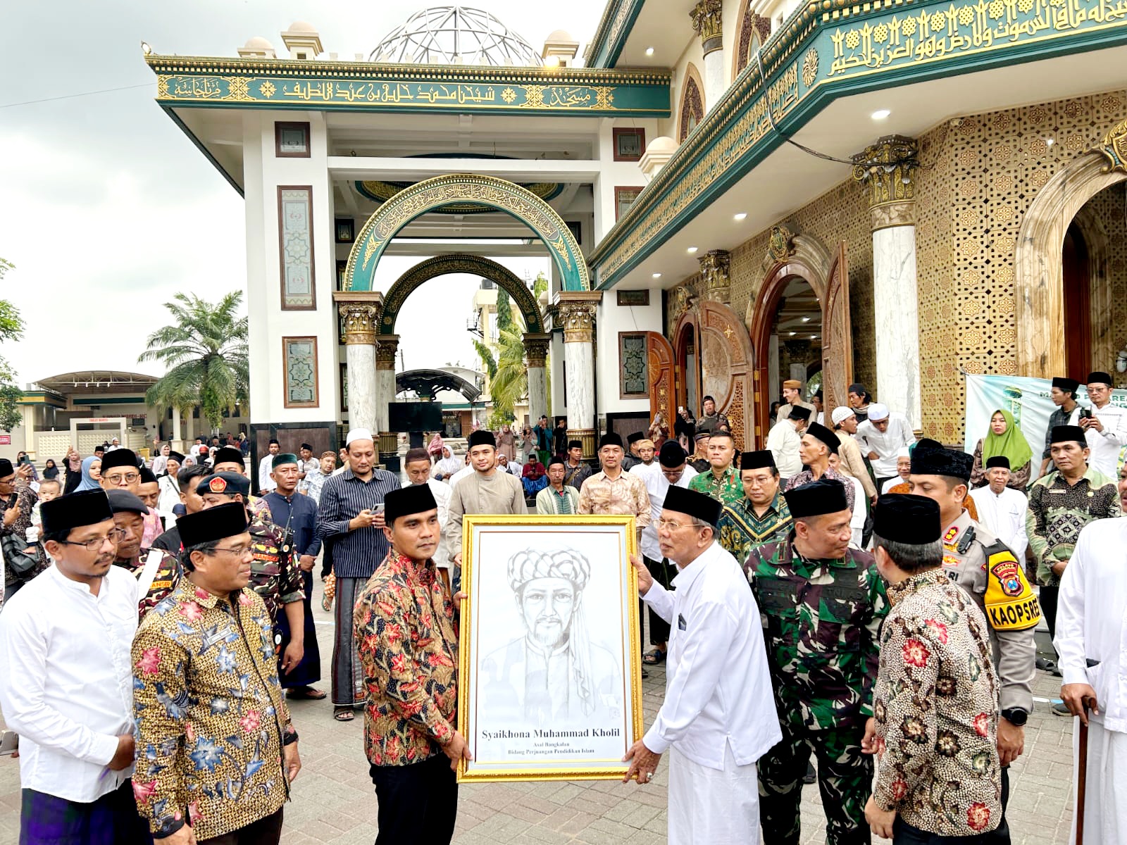 SAMBUT SUKACITA: Bupati Bangkalan Lukman Hakim menyerahkan sketsa Syaikhona Muhammad Kholil ke zuriahnya. (VIVIN AGUSTIN HARTONO/JPRM)
