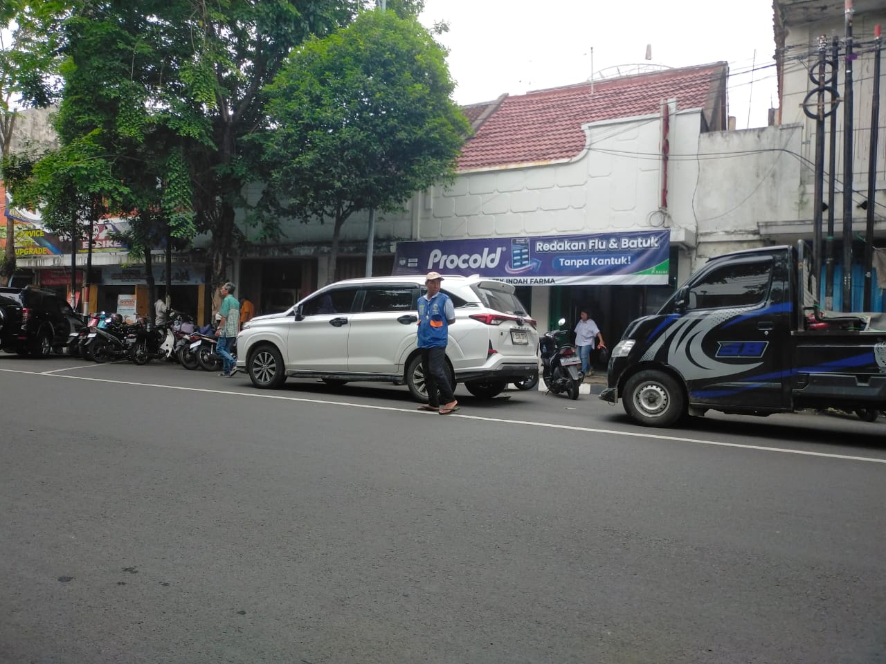 BERTUGAS: Juru parkir (jukir) di Jalan Panglima Sudirman, Bangkalan, mengawal kendaraan, Kamis (20/11).