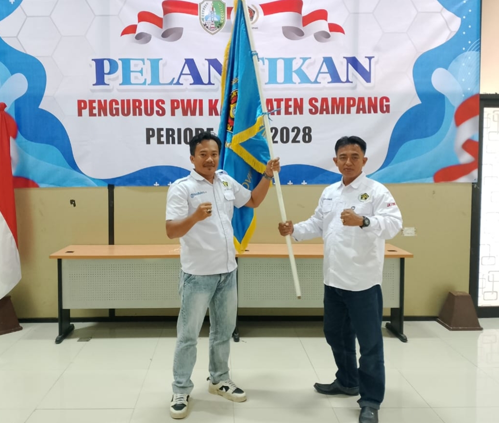 SEMANGAT: Hanggara Pratama Syahputra (kiri) menerima bendera pataka secara simbolis dari Fathor Rahman sebagai tanda pergantian ketua PWI Sampang, di Kantor PWI Jatim, Sabtu (22/11).