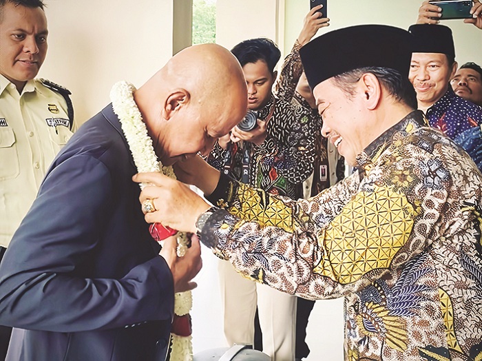 SAMBUTAN HANGAT: Rektor UIN Madura Dr Saiful Hadi, M.Pd mengalungkan bunga kepada Ketua Banggar DPR RI MH Said Abdullah saat peresmian GOR Said Abdullah, Sabtu (22/11). (FAHMI JALIL/JPRM)