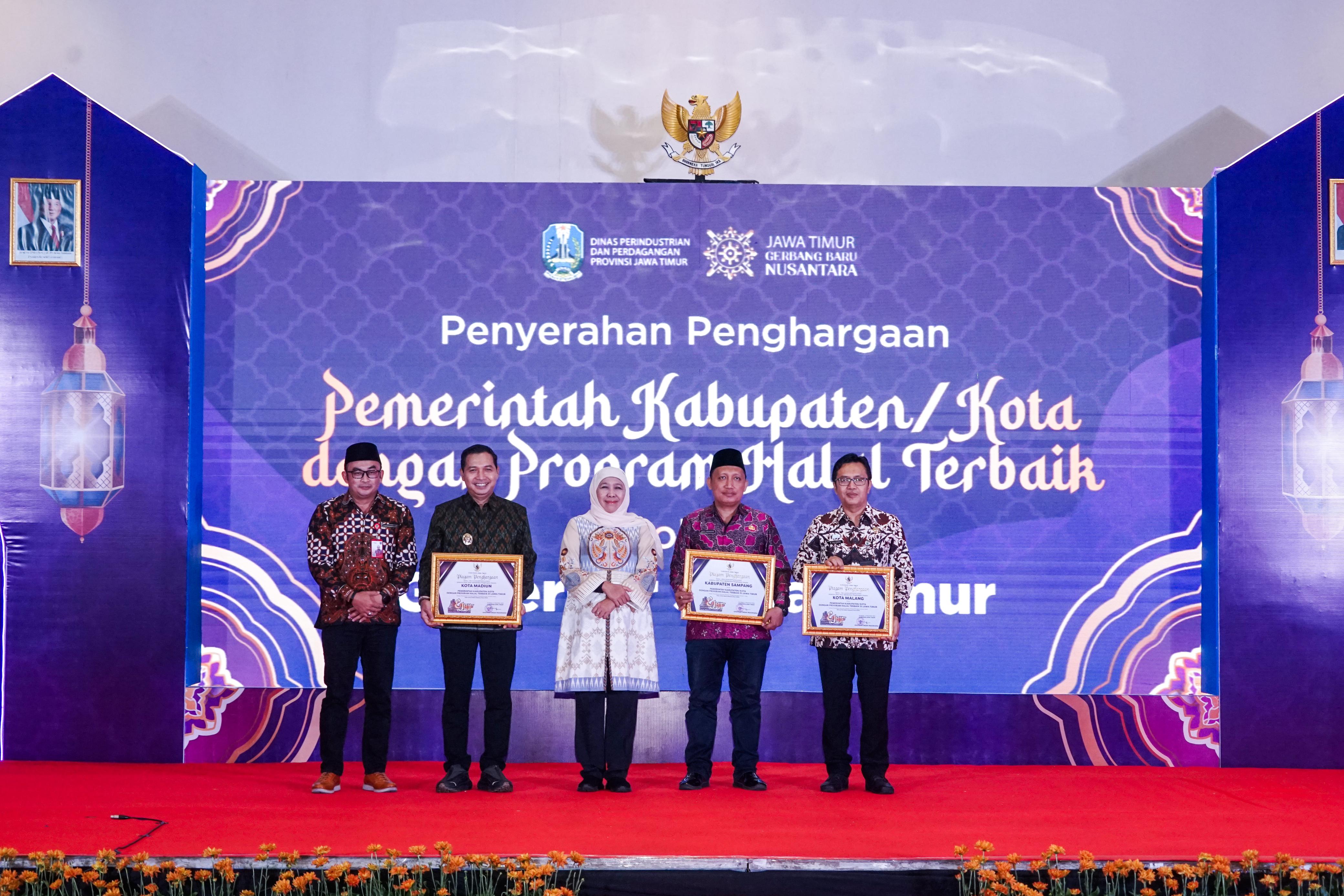 MEMBANGGAKAN: Gubernur Jatim Khofifah Indar Parawansa (tengah) foto bersama Plt Kepala Diskopindag Sampang Zaiful Muqaddas (dua dari kanan) usai menerima penghargaan di Surabaya, Jumat (21/11).
