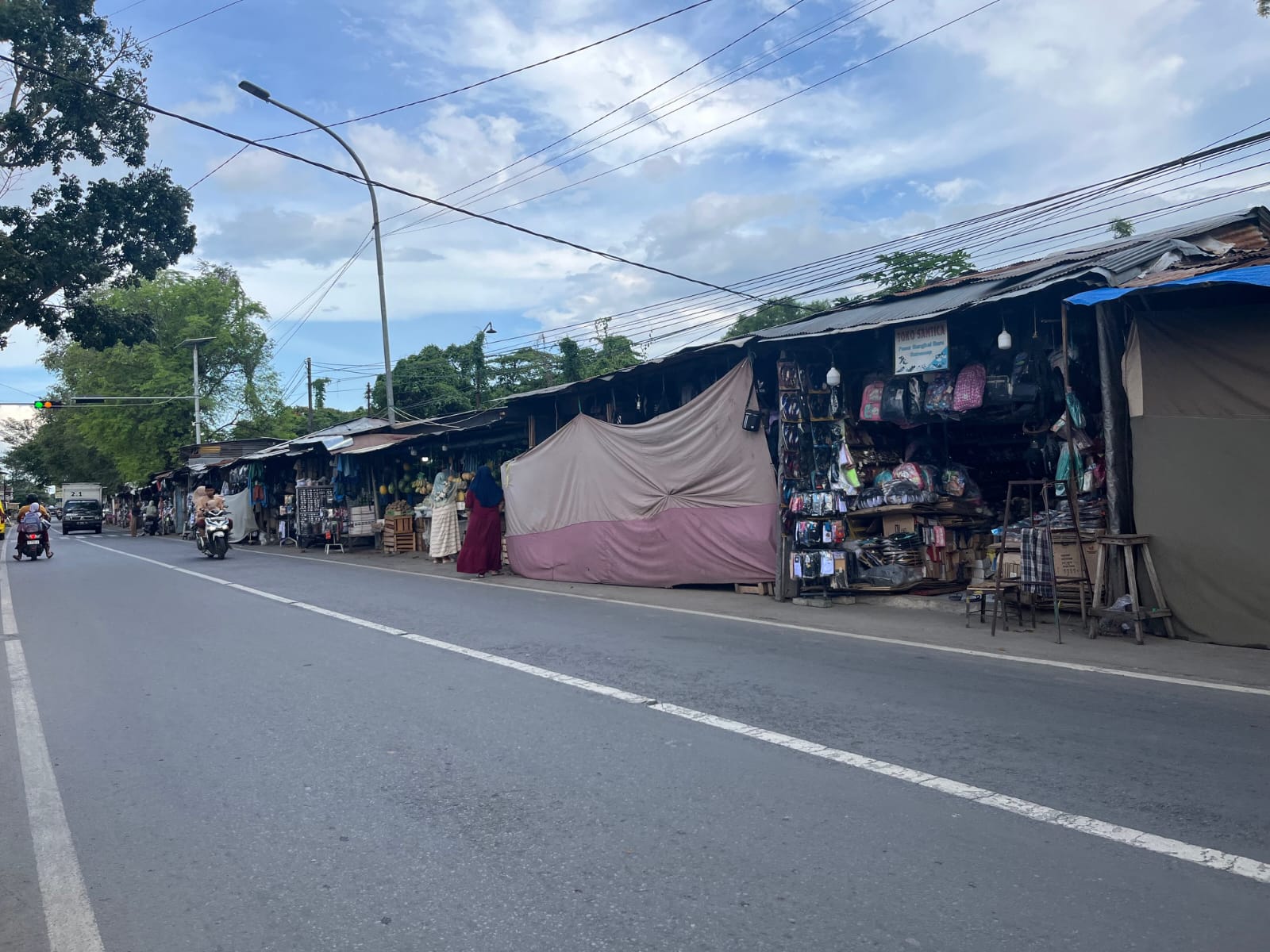 GANGGU LALU LINTAS: Pengendara melintas di depan Pasar Bangkal di Jalan Raya Gapura, Desa Bangkal, Kecamatan Kota, Minggu (23/12).