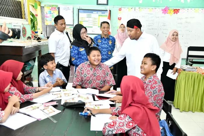 AKRAB: Bupati Sumenep Achmad Fauzi Wongsojudo (pakai belangkon) menyapa murid SDN Pandian 1, Sumenep, Rabu (17/1/2024).