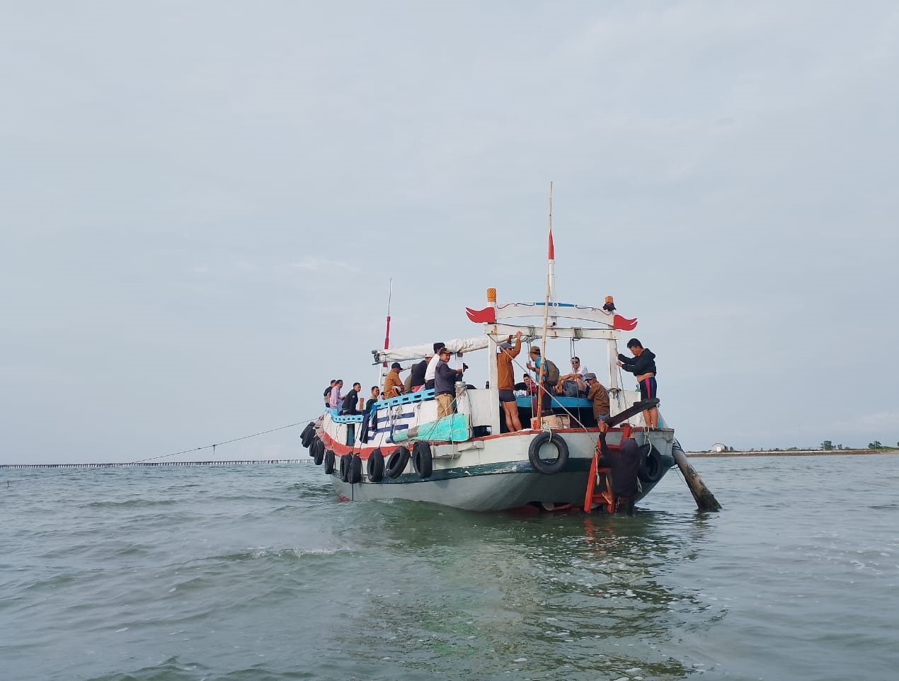 ABDI NEGARA: Sejumlah guru dan nakes menaiki kapal untuk menyebrang ke Pulau Mandangin, Sampang, Senin (24/11).