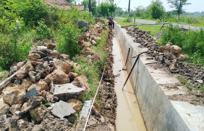 SEUMUR JAGUNG: Pekerja mengkur kerusakan proyek pembangunan saluran di Desa Apaan, Kecamatan Pangarengan yang ambruk. (UBAIDILLAHIR RAIE for Radarmadura.id)