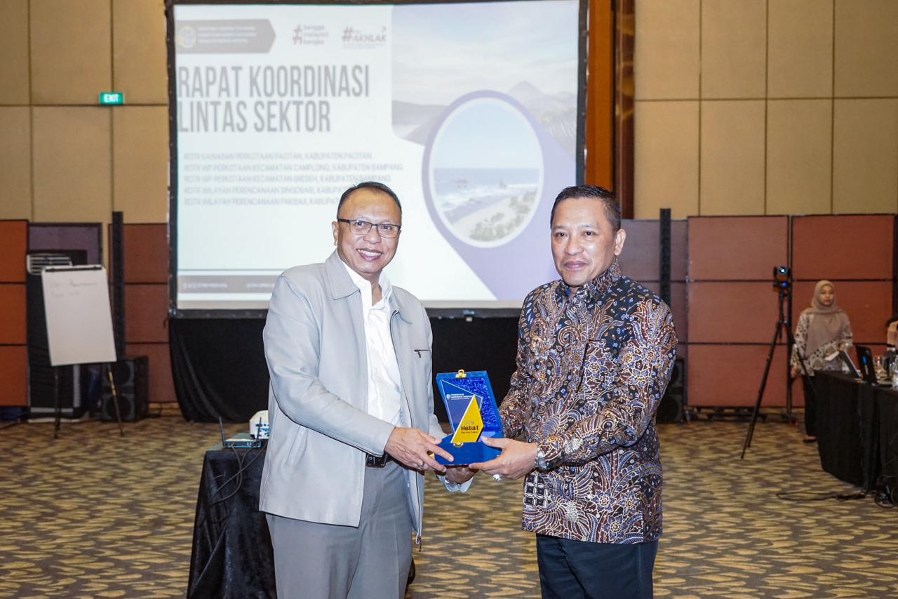 BERSINERGI: Bupati Sampang Slamet Junaidi menyerahkan cendramata kepada perwakilan Kementerian ATR/BPN di Hotel Sheraton Grand Jakarta, Senin (24/11).