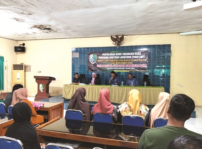 BERI IMBAUAN: Kepala Dinsos PPPA Sampang Moh. Anwari Abdullah menyampaikan sambutan saat penyaluran BLT DBHCHT 2025 Kecamatan Sampang di aula dinsos PPPA, Senin (1/12). (DINSOS PPPA UNTUK JPRM)