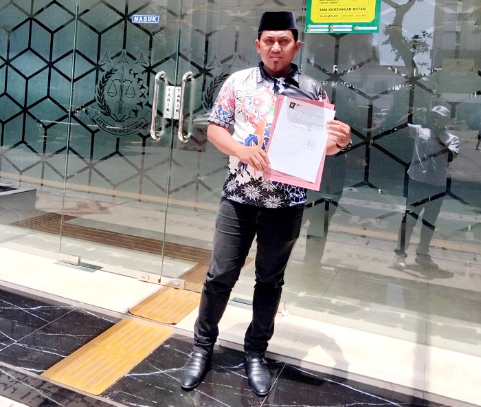 CARI KEADILAN: Pelapor Achmad Salim menunjukkan surat pengaduan terkait dugaan penyelewengan dana PKH di depan kantor Kejati Jatim, Selasa (25/11). (ACHMAD SALIM UNTUK JPRM)