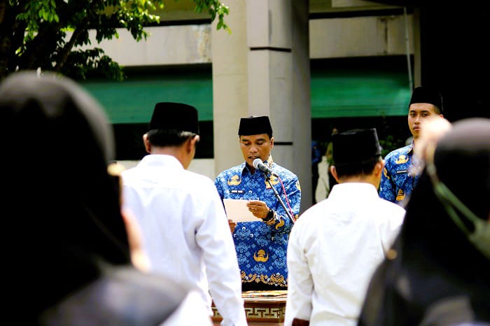 MEMBERI PESAN: Bupati Bangkalan Lukman Hakim menyampaikan sambutan saat acara pengukuhan tambahan masa jabatan anggota BPD di halaman kantor pemkab Senin (1/12). (VIVIN AGUSTIN HARTONO/JPRM)
