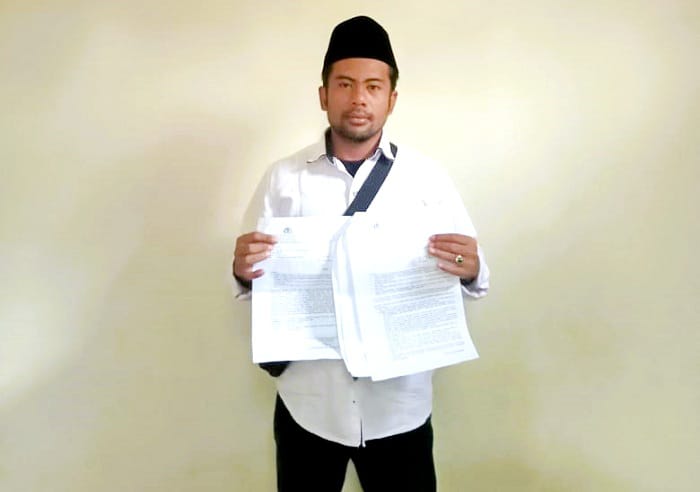 MENCARI KEADILAN: Pelapor Suherman menunjukkan berkas laporan penganiayaan Minggu (12/10). (SUHERMAN UNTUK JPRM)