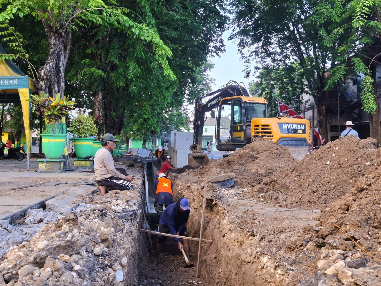 SIBUK: Sejumlah pekerja tengah memasang U-ditch di sebelah timur Taman Bunga Pottre Koneng Sumenep, Senin (1/12).