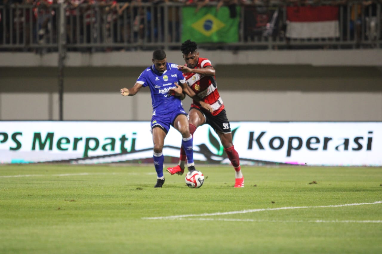 MELAWAN: Bek Madura United Mendonca tenggah mencoba menghalau pemain Persib di Stadion Gelora Ratu Pamelingan Pamekasan, Minggu (30/11).