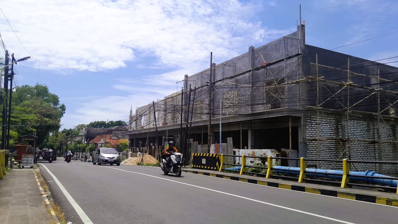 SUMBER PAD: Kendaraan bermotor melintas di sekitar bangunan gedung di Jalan Stadion Pamekasan, Selasa (2/12).