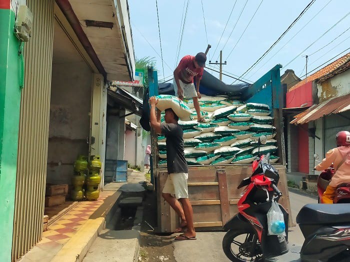 KEBUTUHAN PANGAN: Seorang pekerja menurunkan beras di Kelurahan Pangeranan, Kecamatan Bangkalan, Selasa (2/12). (VIVIN AGUSTIN HARTONO/JPRM)