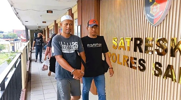 MELANGGAR HUKUM: Tersangka DAP digiring petugas saat dilimpahkan ke Satreskrim Polres Sampang, Selasa (2/12). (HUMAS POLRES UNTUK JPRM)