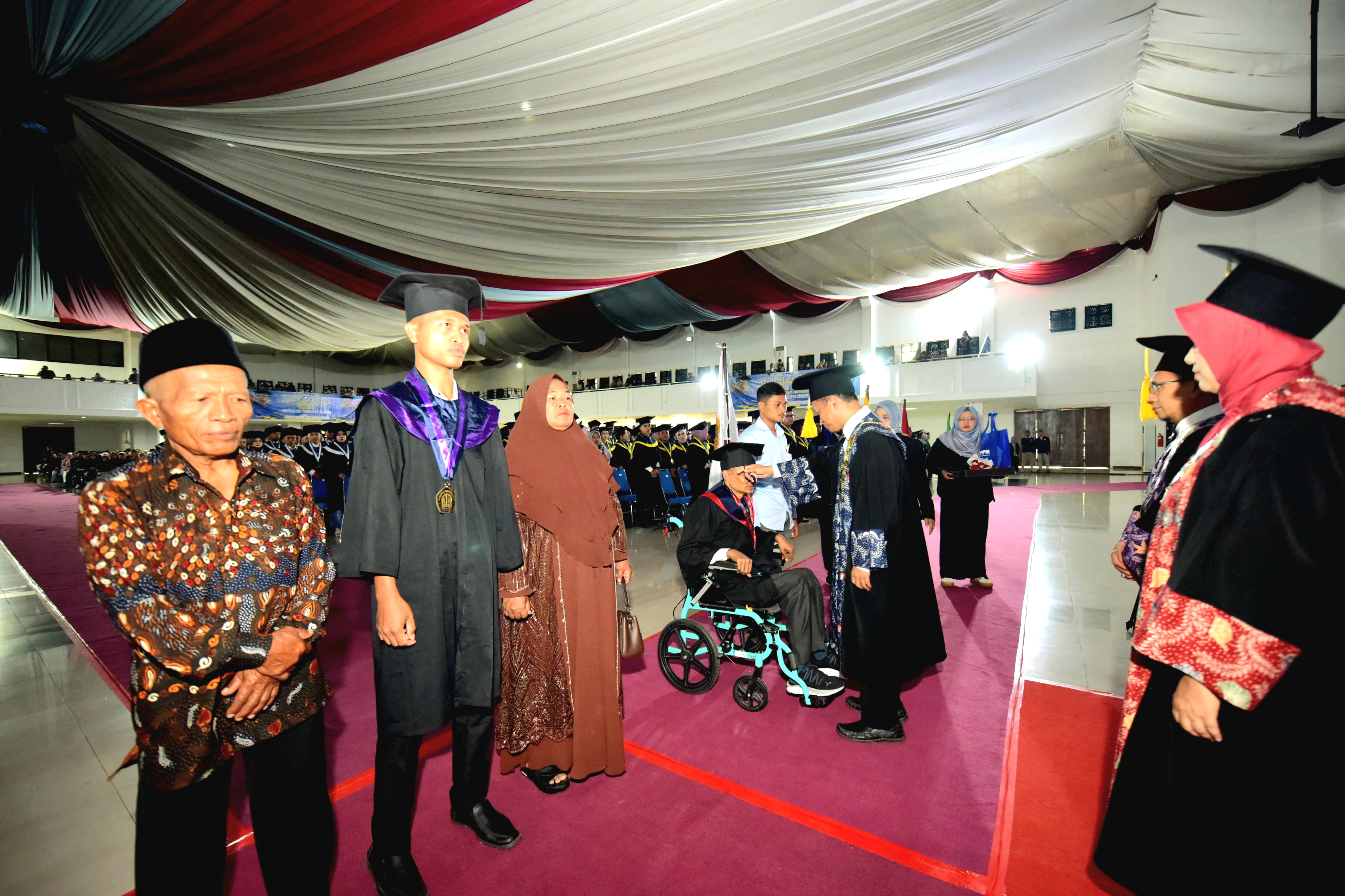 SIMBOLIS: Rektor UTM Prof. Safi memindahkan tali toga Muarah, mahasiswa magister hukum penyandang disabilitas.