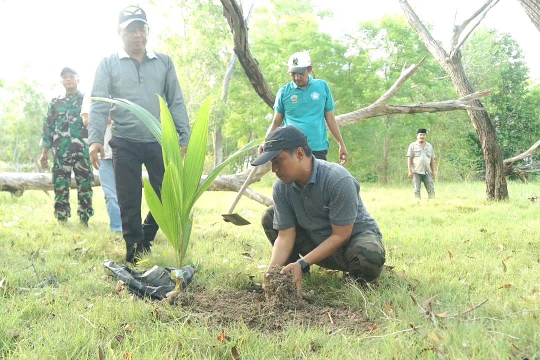 LESTARIKAN LINGKUNGAN: Bupati Bangkalan menanam bibit kelapa di pesisir Kecamatan Sepulu, Jumat (5/12). (PROKOPIM UNTUK JPRM)