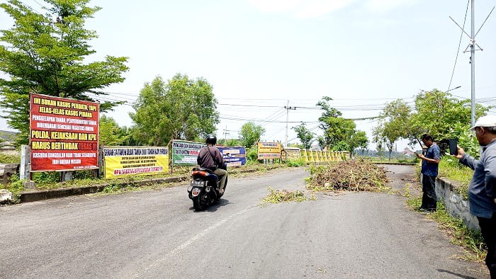 BERMASALAH: Polisi mengawal pengendara di Jalan Kinibalu Bangkalan, Senin (2/12). (ZEINAL ABIDIN/JPRM)