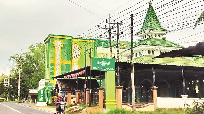 MEGAH: Masyarakat melintas di depan kantor pusat BMT NU di Kecamatan Gapura, Sumenep, Minggu (7/12). (HAFID UNTUK JPRM)