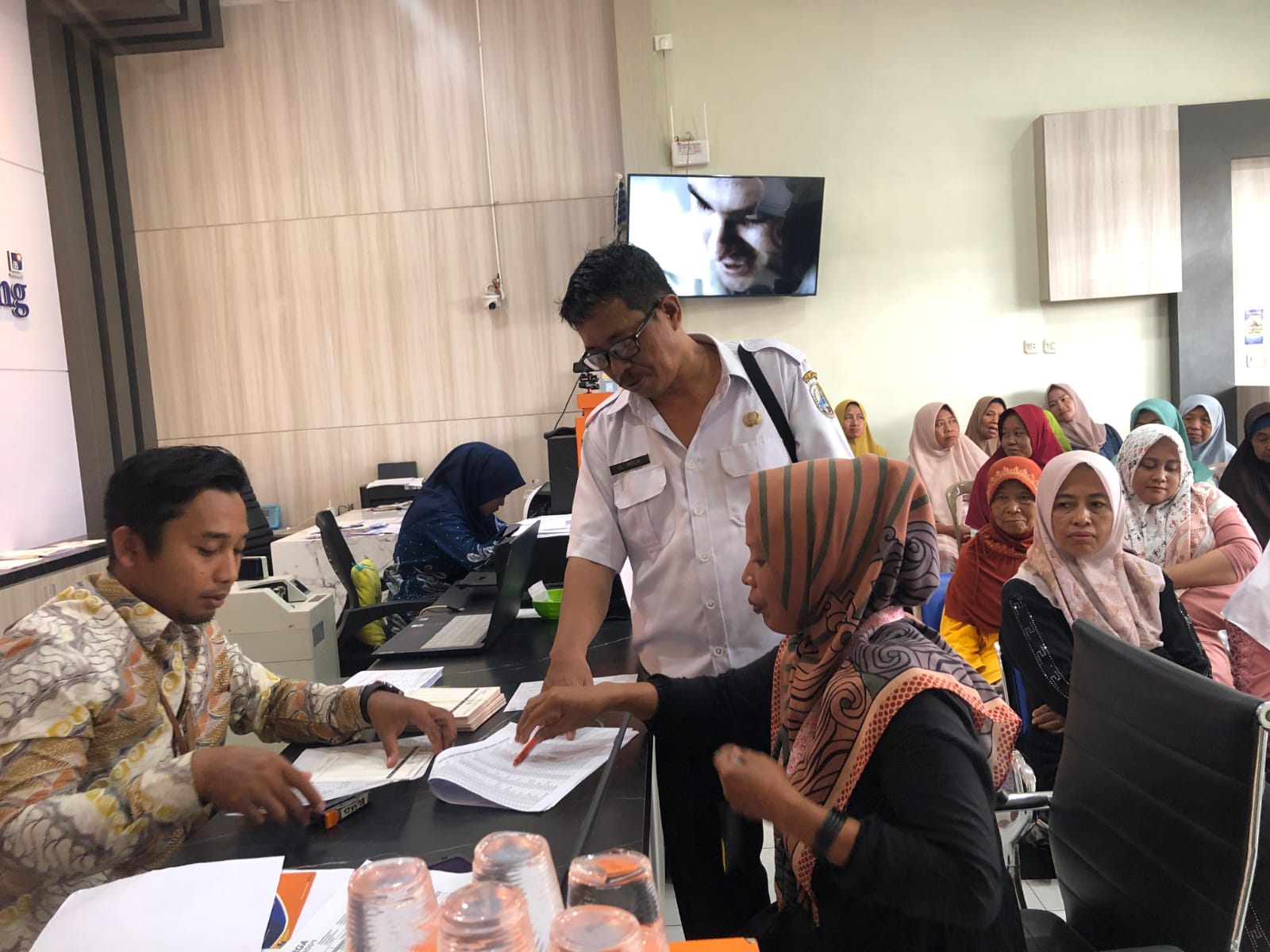 DIKROSCEK: Pegawai Kantor Kas Bank Sampang Karang Penang mengecek data penerima BLT DBHCHT sebelum bantuan disalurkan, Rabu (26/11).