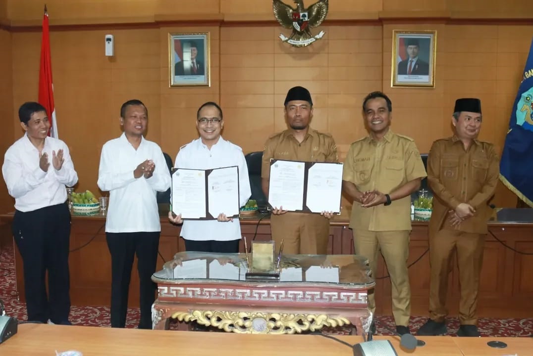 KOLABORASI: Kadispendik  dan Direktur Pascasarjana menunjukkan dokumen MoU yang telah ditandatangani dengan didampingi Bupati Bangkalan beserta wabup  dan rektor UTM