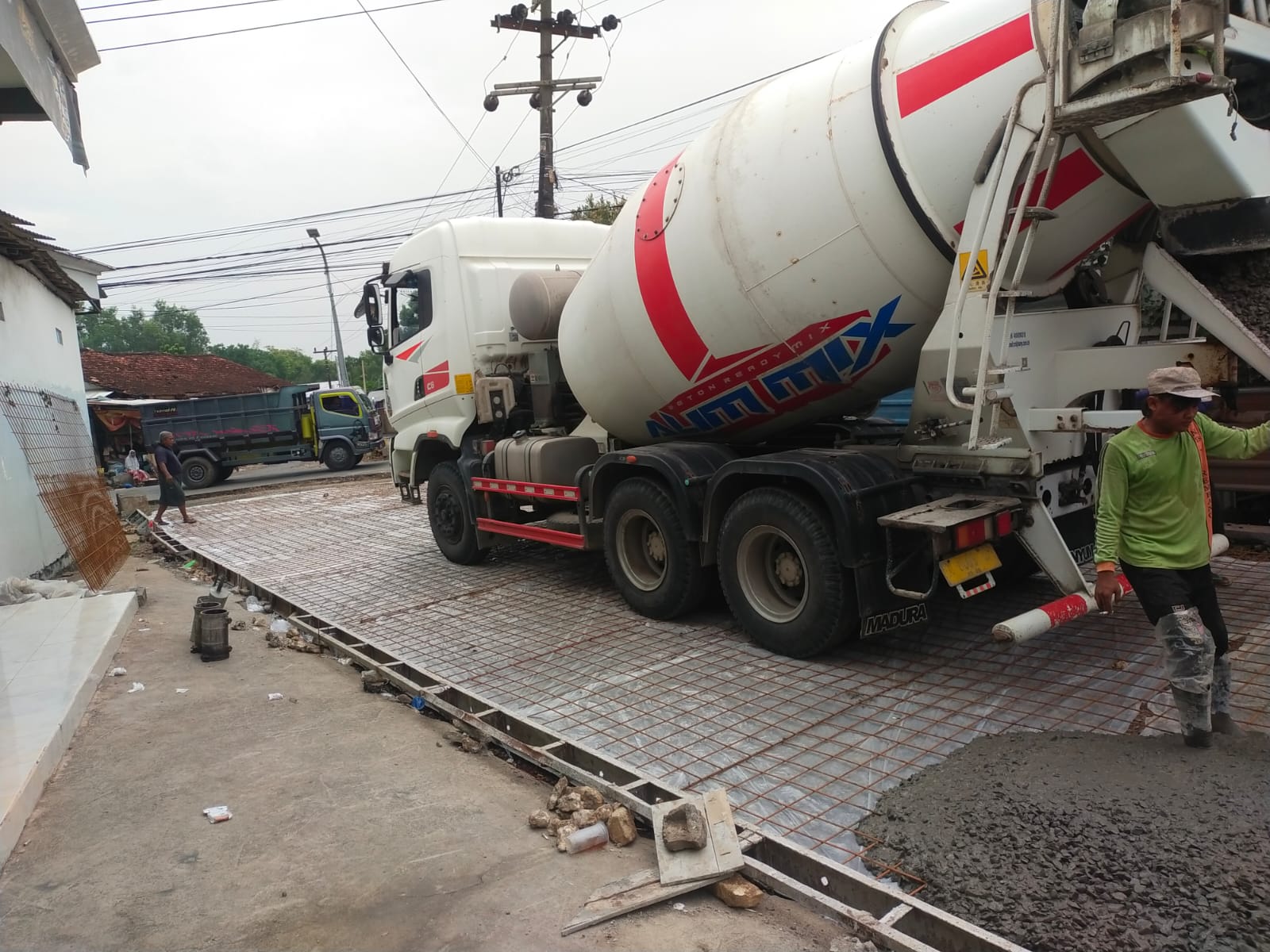 SEDANG DIKERJAKAN: Proses pengecoran jalan menggunakan beton ready mix pada ruas Jalan Paopale-Rabiyan, Sampang.
