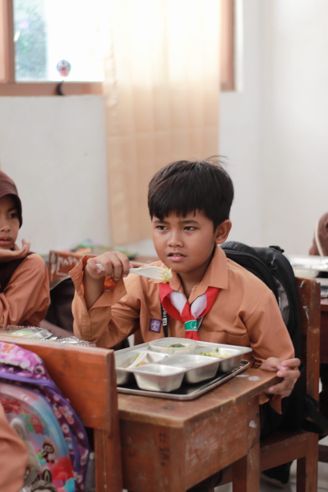 Salman sedang makan jatah MBG di sekolahnya di SDN Dulang, Torjun, Sampang.