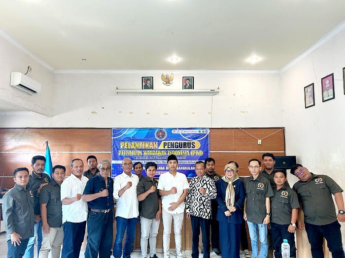 KHIDMAT: Wakil Ketua PWI Jatim Mahmud Suhermono (kiri) menyerahkan pataka kepada Ketua PWI Bangkalan Mahmud Ismail (kanan) saat pelantikan Rabu (10/12). (VIVIN AGUSTIN HARTONO/JPRM)